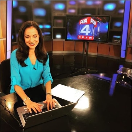 Natalie Solis working at her desk in the Fox 4 Newsroom